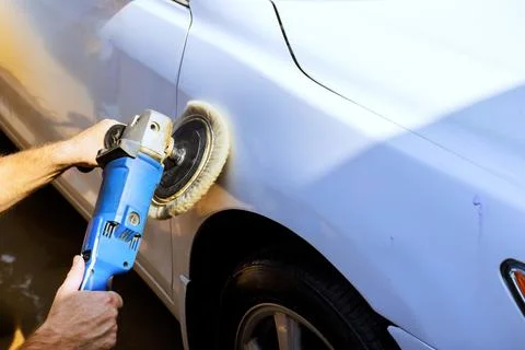 Car detailing process includes polishing white vehicle with grinder Stock Photos