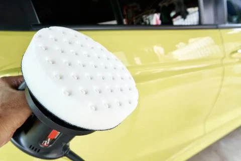 Car detailing of worker's hand using polishing and waxing in garage with copy Stock Photos