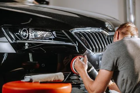 Car details concept - hands with orbital polisher in a car studio, detailing Фото