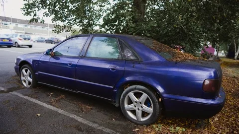 Car with dirty windows and flat tires, dry leaves fall autumn bird droppings Stock Footage 303372733