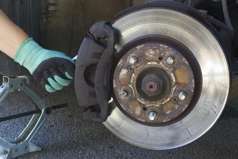 Car disk brake pad replacement service with hand of mechanic, brake disc rotor Foto stock