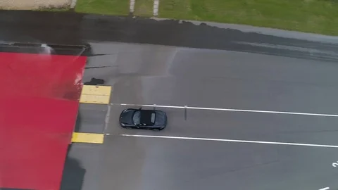 Car doing 360 on drift pan, tracked from above drone aerial 4k Stock Footage 114153288