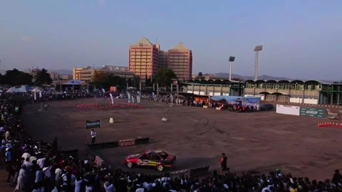 Car doing stunts during a public event and crashing into a barrier and almost Stock Footage 327494175