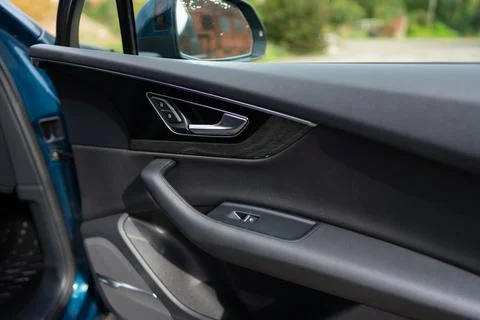 Car door panel inside luxury vehicle with handle and switch button control from Photos