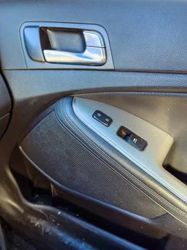 A car door panel shows the window controls and handle. The focus is on the de Stock Photos