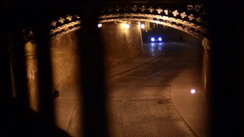 Car down in an underpass at night with headlights on, seen after the bridge r Stock Footage 72190366