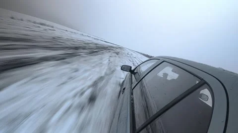 Car drifting on snowy road from dynamic angle Stock Footage 327928576