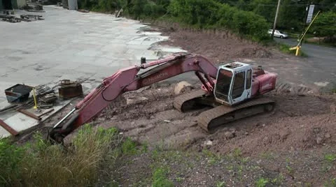 Car drive past back-hoe through parking lot Stock Footage 10586237