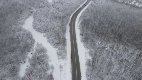 Car drive in snow winter day on the road in mountain range aerial view Vídeo Stock 231644320