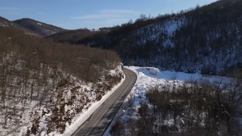 Car drive in snow winter day on the road in mountain range aerial view Stock Footage 232802201