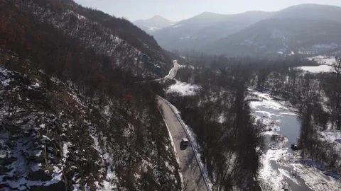 Car drive in snow winter day on the road in mountain range aerial view 스톡 동영상 232802203