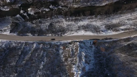 Car drive in snow winter day on the road in mountain range aerial view Stock Footage 232804822