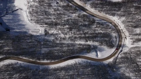 Car drive in snow winter day on the road in mountain range aerial view Stock Footage 232948643