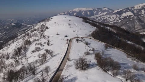 Car drive in snow winter day on the road in mountain range aerial view Stock Footage 232957166