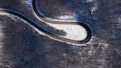 Car drive in snow winter day on the road in mountain range aerial view Stock Footage 261123704