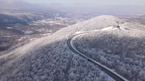 Car drive in snow winter day on the road in mountain range aerial view Stock Footage 262272835