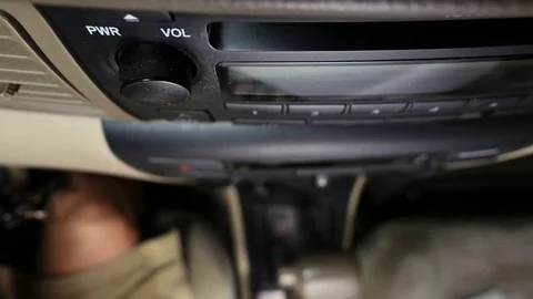Car driver inserting a music CD into the dash player Stock Footage
