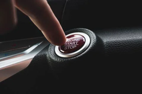 Car driver press to the engine start stop button Stock Photos