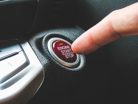 Car driver press to the engine start stop button Stock Photos