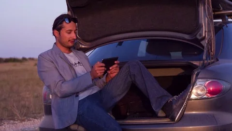 The car driver rests and plays on the tablet Stock Footage 81064660