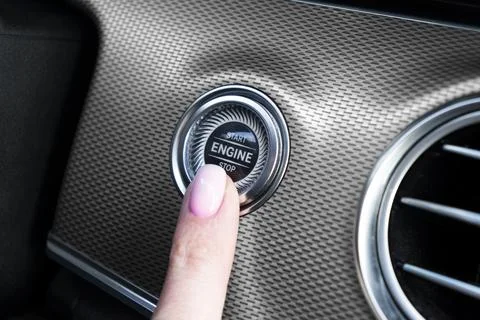 Car driver starting the engine with start stop engine button. Finger press .. Stock Photos