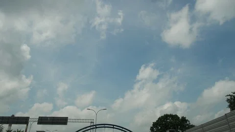 The car drives along the road, the camera looks up at the sky, clouds, signs and Stock Footage