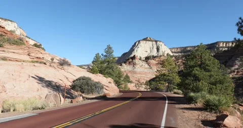 A car drives down an empty road in Zion National Park Stock Footage 146197814
