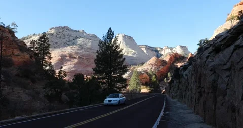A car drives down an empty road in Zion National Park Stock Footage 146198441