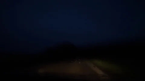 A car drives at night, it is raining, the wipers are working, the headlights of Stock-Footage 114890350