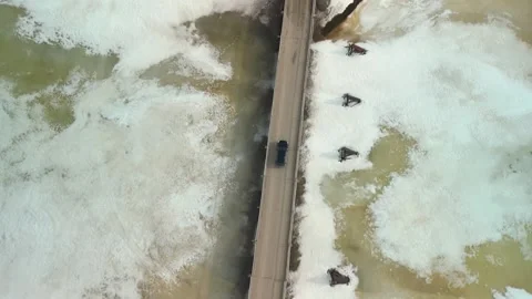 The car drives over a bridge over a frozen river Stock Footage 240732612