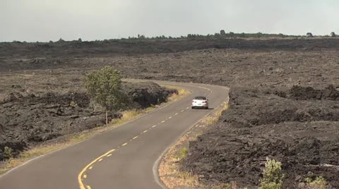 A Car Drives On A Road going Through a Lava Field Stockbeeldmateriaal 19265551