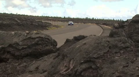 A Car Drives On A Road going Through a Lava Field 2 Video stock 19282141