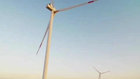 A car drives slowly between wind generators. Glare of the setting sun. Electric  Stock Footage 288193835