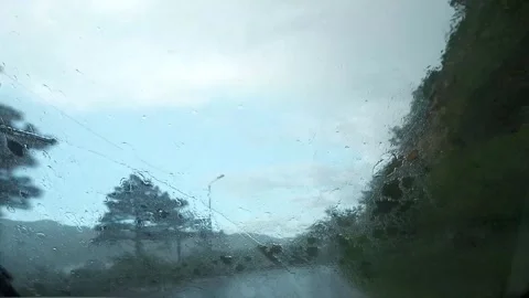 A car drives through a bridge on a rainy day, with heavy rain blurring the view Stock Footage 277296945