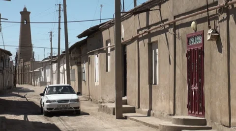 Car drives through bumpy street in old Uzbek town Video stock 30268044