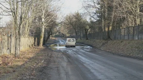 Car drives through deep puddle in the countryside Stock Footage 71842357