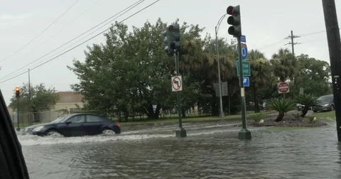Car drives through a flooded intersection of I10 in New Orleans Stock Footage 79445695