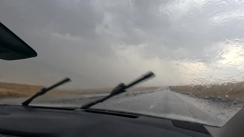 Car drives through heavy rain front view as windshield wipers clear water Stock Footage 343805244