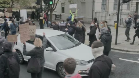 Car Drives through Protesters marching through London Streets BLM Protest London Stock Footage 132107762