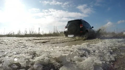 Car drives through a puddle. On camera fly spray and ice. Video stock 60259455