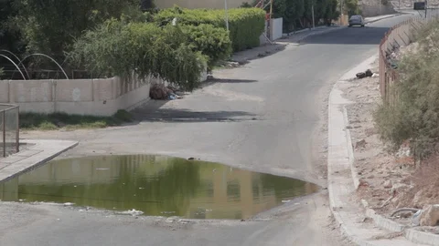 A car drives through a puddle on a flooded road Egypt Stock-Footage 90926200