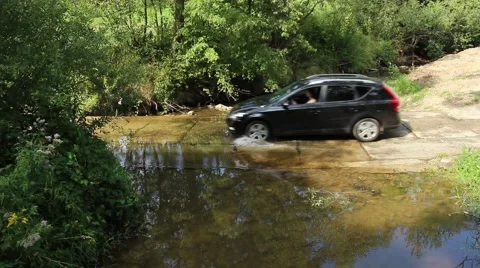 Car drives through a river Stock Footage 58284371