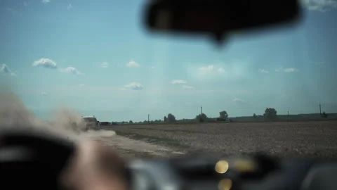 Car driving across a field, picking up dust from a dirt road. Stock Footage 280677285