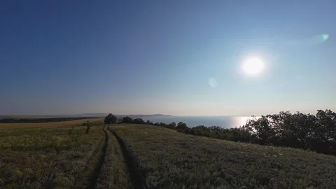 Car driving along elevated field near wide river in summer Stock Footage 315594680