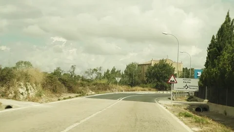 Car driving along empty road on a cloudy day in Spain - Slowmotion Video stock 80383646