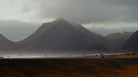 Car Driving Along on Empty Road with Mountain in sunset, North coast, Iceland Stock Footage 260917383