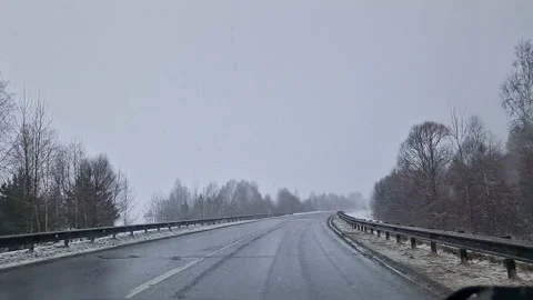 The car is driving along the highway through snow and blizzard. Video through Vídeo Stock 175185143