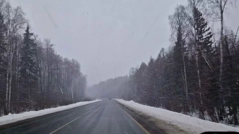 The car is driving along the highway through snow and blizzard. Video through Vídeo Stock 176899265