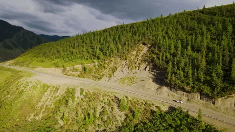 A car is driving along a mountain road near the forest Stock Footage 244651610