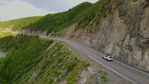 A car is driving along a mountain road near the forest Stock Footage 244651723